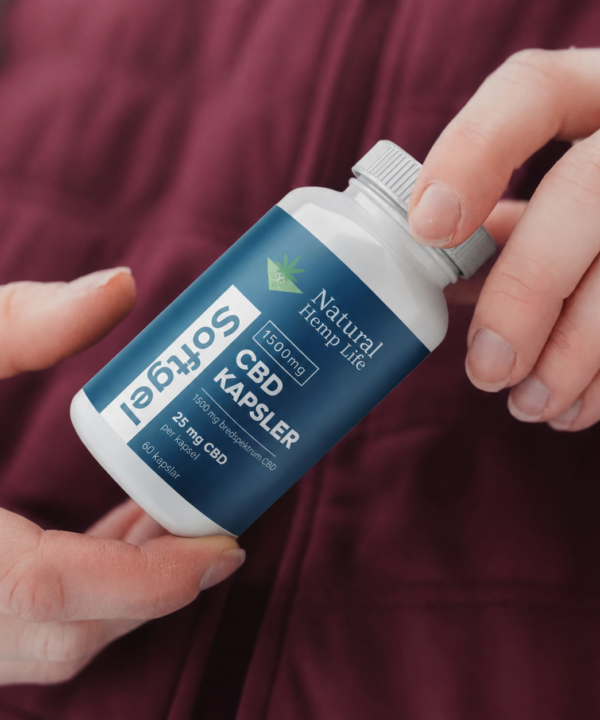 Person i bordeauxrød trøje holder en dåse CBD Kapsler Softgel 1500 mg fra Natural Hemp Life