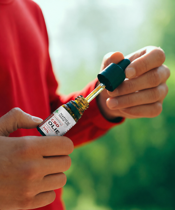 Person i rød trøje doserer CBD Olie 30% fra Natural Hemp Life udendørs