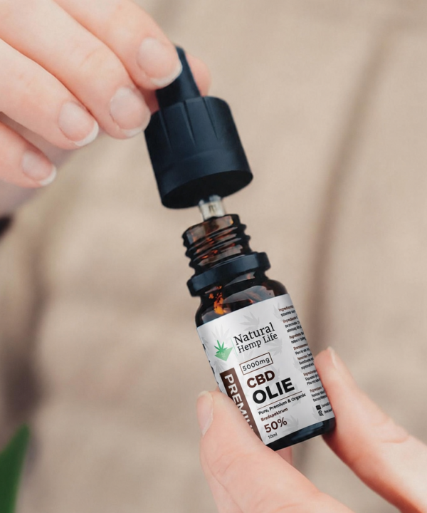 Hånd skruer låget af en flaske CBD Olie 50% fra Natural Hemp Life