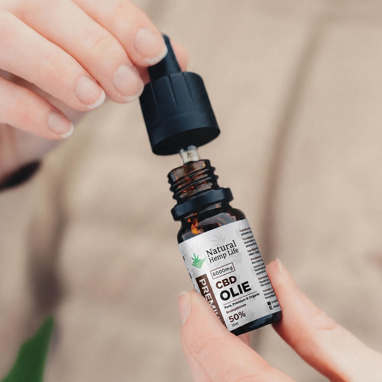 Hånd skruer låget af en flaske CBD Olie 50% fra Natural Hemp Life