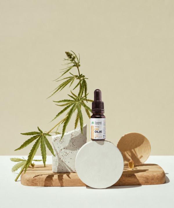 Dråbeflaske med CBG + CBD Olie 10% placeret ved en hampeplante